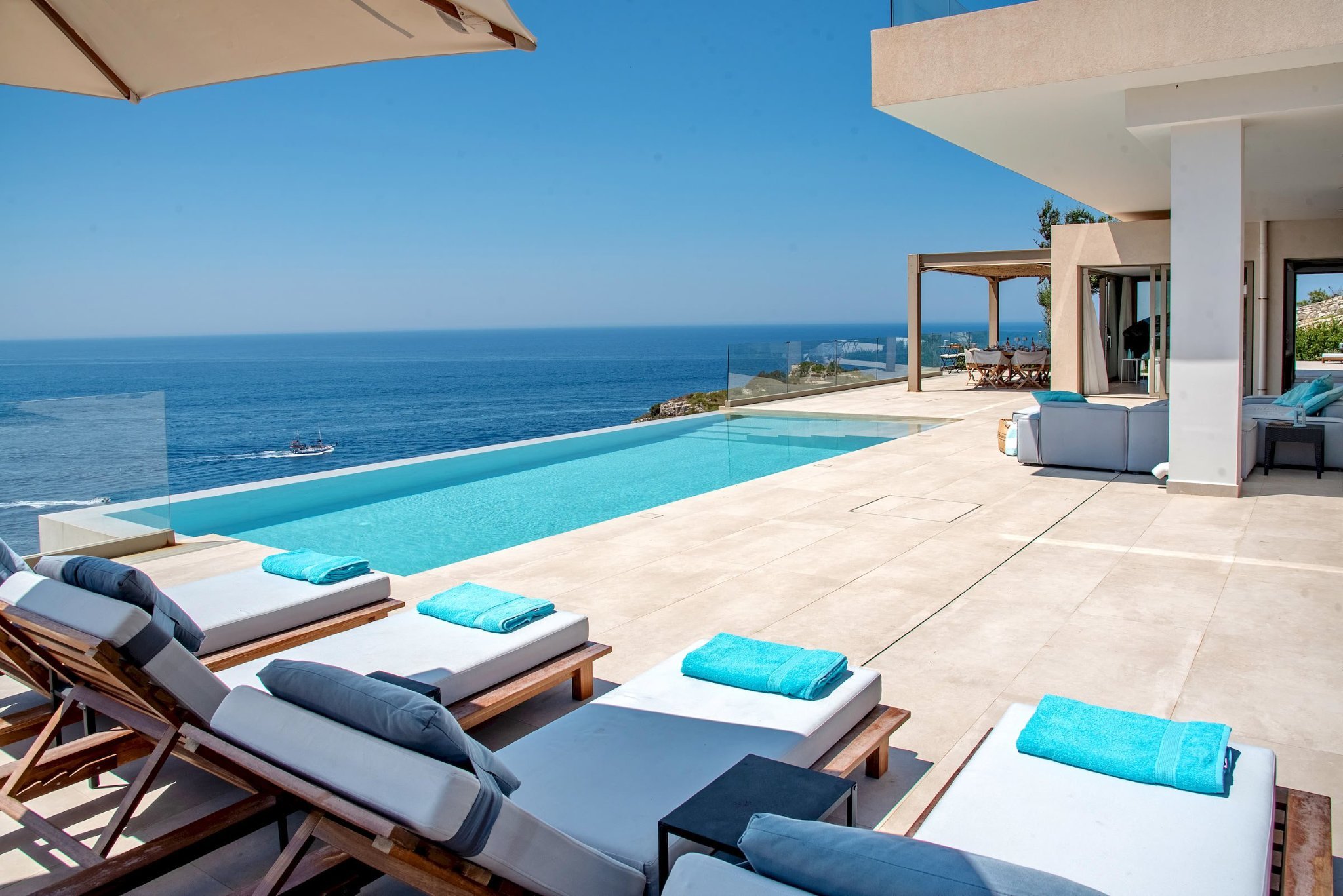 SeaWhisper's infinity pool and sun loungers above the sea